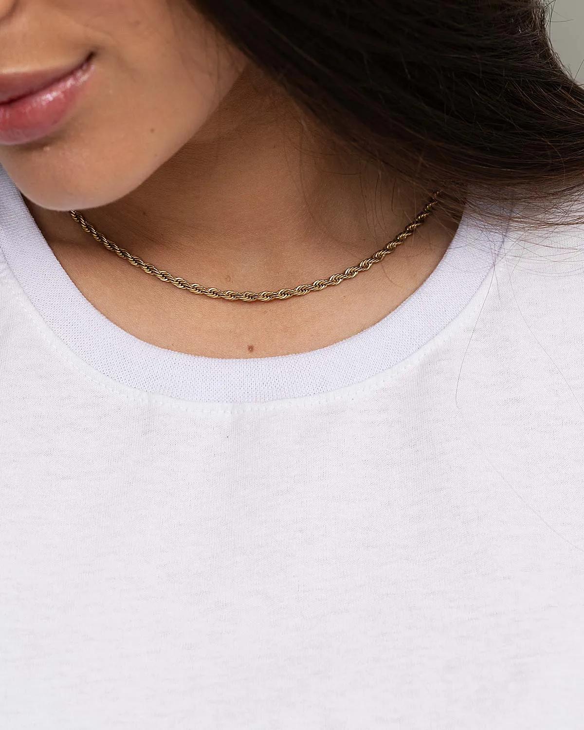 “Close-up of ribbed neckline on women’s white 100% cotton T-shirt.”
