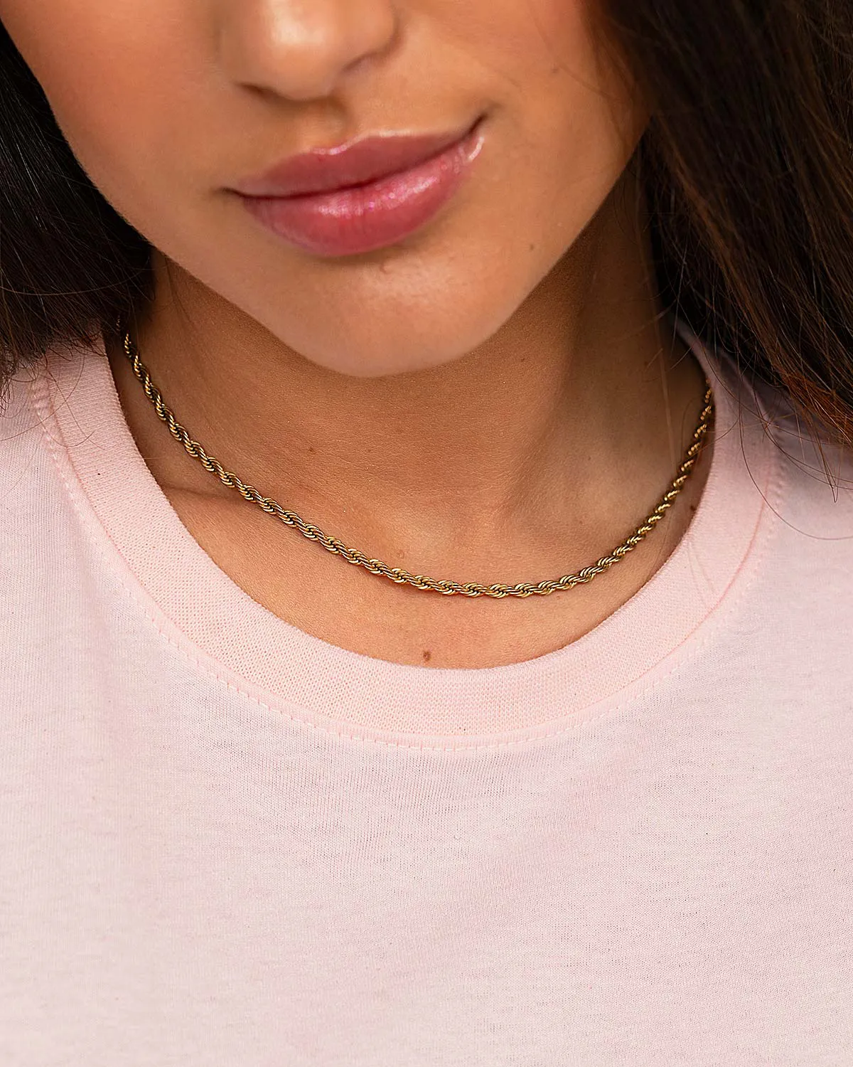 “Close-up of ribbed neckline on women’s pink 100% cotton T-shirt.”