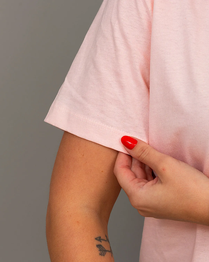 “Close-up of sleeve detail on women’s pink 100% cotton T-shirt.”