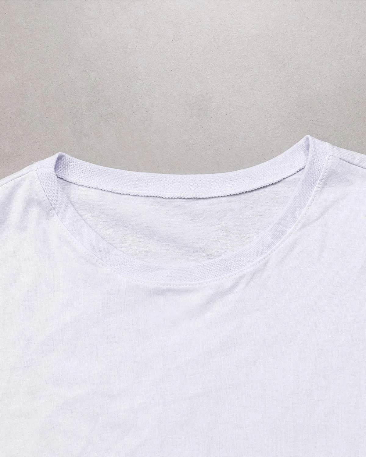 “Fabric texture detail of women’s white 100% cotton relaxed fit T-shirt.”