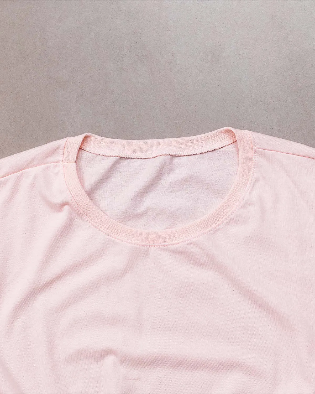 “Fabric texture detail of women’s pink 100% cotton relaxed fit T-shirt.”